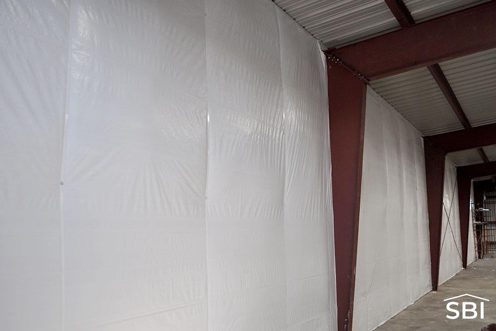 white faced insulation in a red iron building, this is a vertical wall and column
